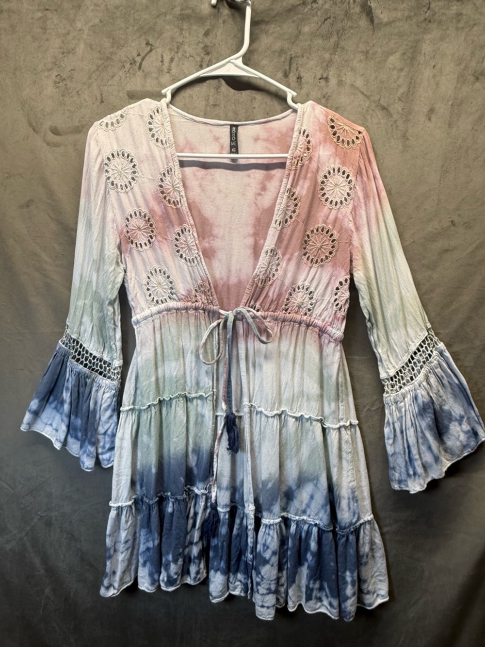 Tie Dye Boho Me tunic top v-neck, eyelet embroidery, and tiered flare sleeves.